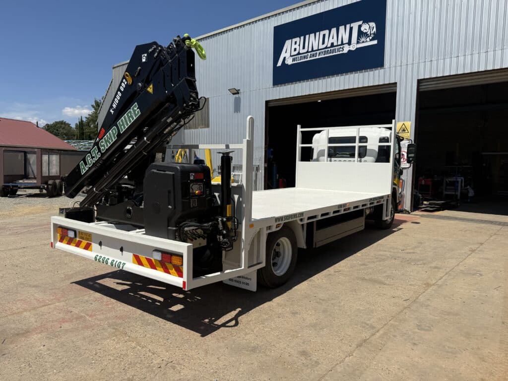 Medium sized truck with back hoist; back view.