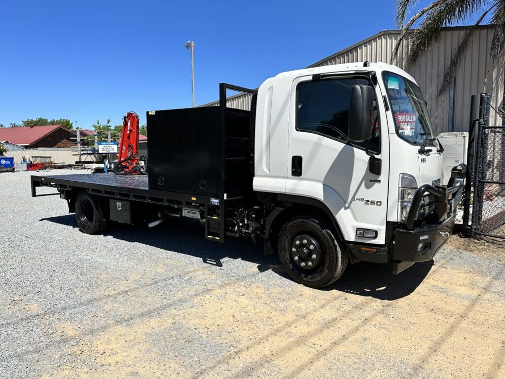Medium sized truck with back hoist; front view.