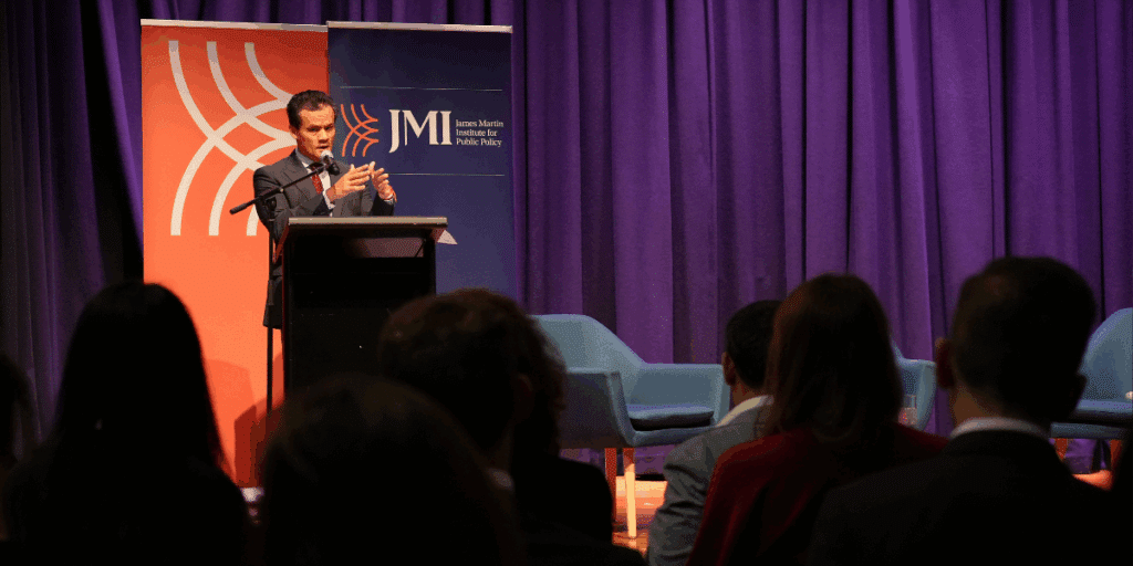 Man speaking at lectern in JMI function.