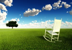 An empty rocking chair outside on a beautiful day, inviting us to take time out.