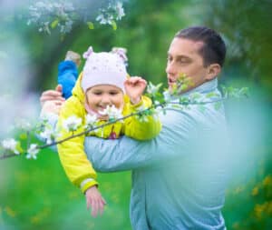Father playing aeroplanes with his baby who is laughing.