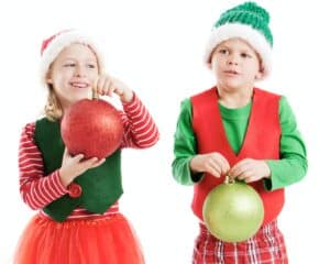 A girl and a boy dressed as Santa's Helpers.