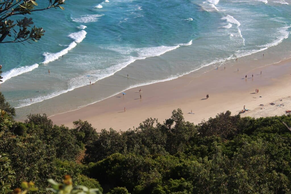 Shot of beach from afar, people standing near water